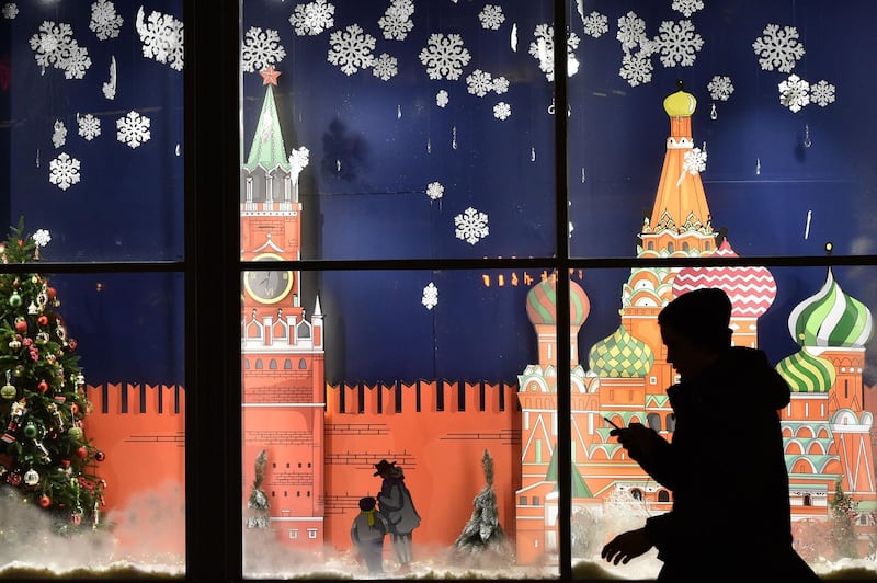 A man walks in front of a shop window decorated for the upcoming Christmas holidays in Moscow. Vasily Maximov / AFP Photo