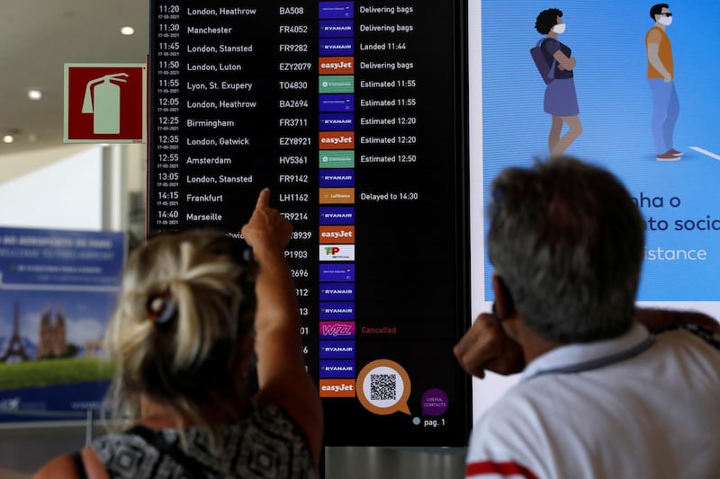 People watch a Faro Airport arrivals screen display information in Faro, Portugal. Reuters