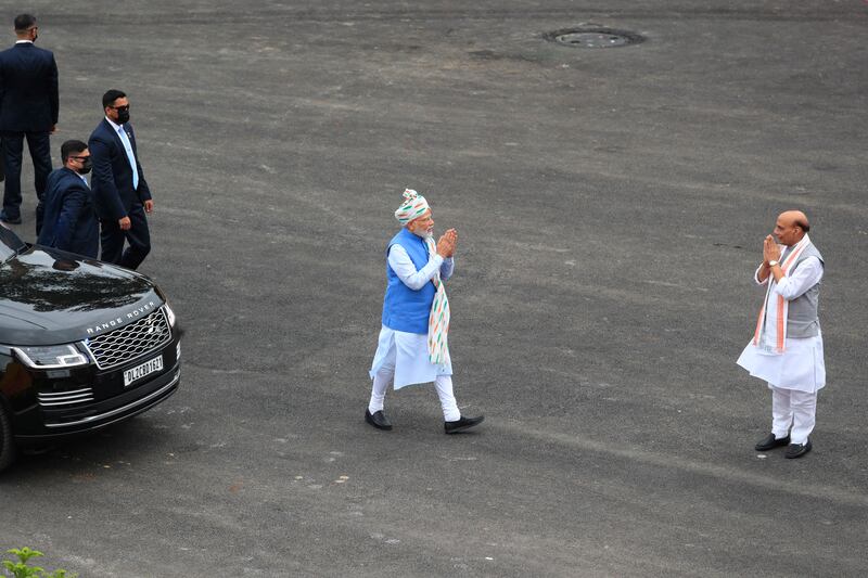 The prime minister, centre, is greeted by Defence Minister Rajnath Singh at the Red Fort. AP