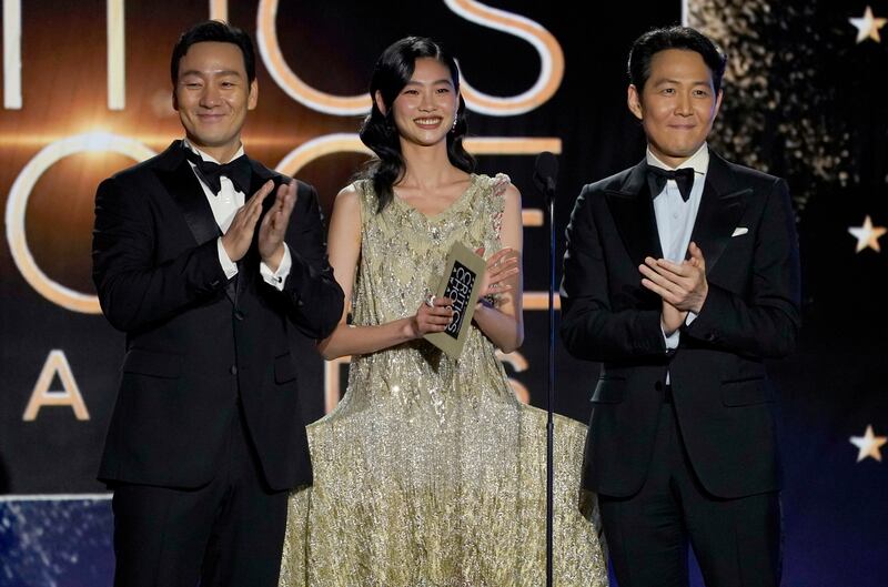 From left, Park Hae-soo, HoYeon Jung, and Lee Jung-jae present the award for Best Actress in a Limited Series. AP