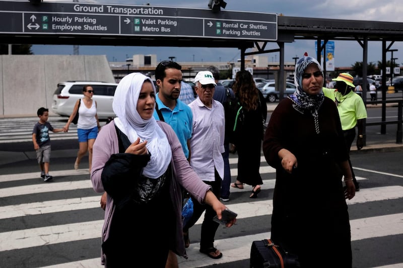 Air passengers walk into Washington Dulles International Airport after a federal judge ruled Thursday that President Trump's temporary ban on travelers from six Muslim-majority countries cannot stop grandparents and other relatives of U.S. citizens from entering the country in Dulles, Virginia, U.S., July 14, 2017. REUTERS/James Lawler Duggan