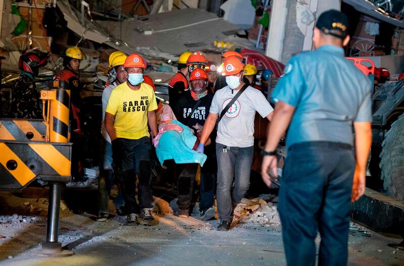 Rescue workers search for survivors in a collapsed Chuzon Super Market in Porac, Pampanga. AFP