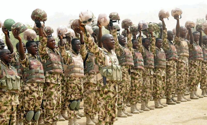 In this handout picture released by State House Photo on February 26, 2015, a detachment of soldiers fighting Boko Haram Islamists raises helmets to salute Nigerian President Goodluck Jonathan  on his arrival in the town of Mubi, recently recaptured from insurgents. Nigeria's President Goodluck Jonathan visited the scene of what is feared to be Boko Haram's worst massacre and vowed that the insurgency would soon be over. AFP PHOTO/ HO/ STATE HOUSE PHOTO
RESTRICTED TO EDITORIAL USE / MANDATORY CREDIT: "AFP PHOTO/ HO/ STATE HOUSE PHOTO"/ NO MARKETING - NO ADVERTISING CAMPAIGNS – NO A LA CARTE SALES / DISTRIBUTED AS A SERVICE TO CLIENTS / (Photo by HO / STATE HOUSE PHOTO / AFP)