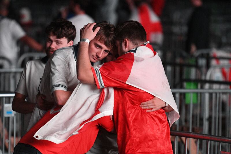 An England fan is consoled in Manchester.