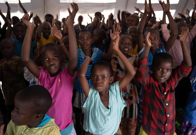 Children clap while learning Rwanda national anthem in Nyarushishi transit center in western Rwanda on January 31, 2020. - The center is handled by the Rwanda Demobilization and Reintegration commission and host 1880 women and children transferred from eastern DRC. Most of them are dependants of former Rwandan rebel fighters belonging to armed groups. (Photo by Simon Wohlfahrt / AFP)