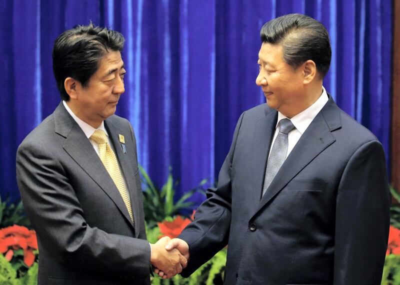 China's President Xi Jinping (R) shakes hands with Japan's Prime Minister Shinzo Abe (L) at the Great Hall of the People on the sidelines of the Asia-Pacific Economic Cooperation (APEC) Summit in Beijing on November 10, 2014. Top leaders and ministers of the 21-member APEC grouping are meeting in Beijing from November 7 to 11.    AFP PHOTO / POOL / Kim Kyung-Hoon / AFP PHOTO / POOL / KIM KYUNG-HOON