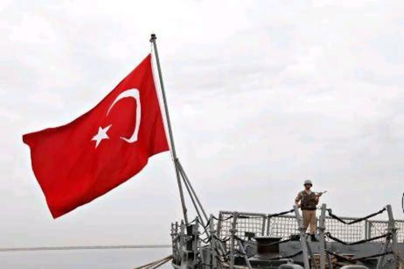 A soldier stands guard on the Nato anti-piracy ship, TCG Giresun, flying the Turkish flag, that is docked at Port Rashid in Bur Dubai.