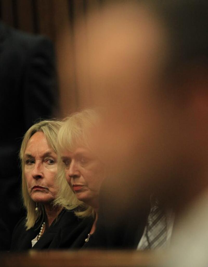 June Steenkamp, left, mother of the deceased, glances at Oscar Pistorius, foreground, as he sits in the dock on March 3, 2014. Themba Hadebe / EPA