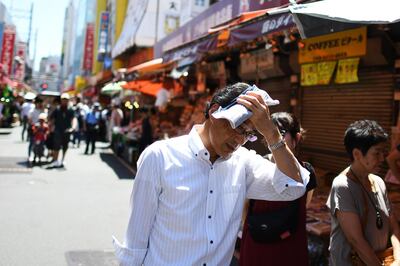 (FILES) In this file photo taken on August 7, 2019 people walk in the street during a hot day in Tokyo's district of Ueno. A damning new UN report published September 22, 2019 said the world is falling badly behind in the race to avert climate disaster as a result of runaway warming, with the five-year period ending 2019 set to be the hottest ever. It comes ahead of a major UN climate summit Monday that will be attended by more than 60 world leaders, as Secretary-General Antonio Guterres pushes for countries to increase their greenhouse gas reduction targets. / AFP / CHARLY TRIBALLEAU
