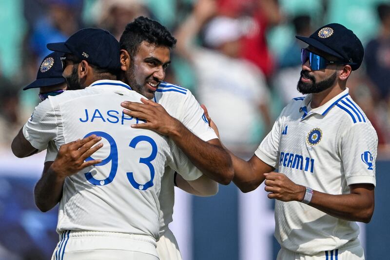 India's Ravichandran Ashwin, centre, celebrates with teammates after taking his 500th wicket, England's Zak Crawley. AFP