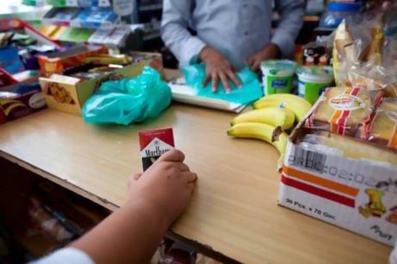 A young boy buys cigarettes he said they were for his father at a shop in Sharjah yesterday. Christopher Pike / The National