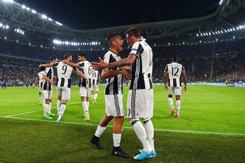 Paulo Dybala of Juventus celebrates with Mario Mandzukic after scoring his team's second goal. Mike Hewitt / Getty Images