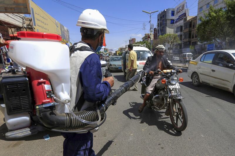 A Yemeni worker sprays disinfecting liquid in a street of the capital Sanaa. AFP