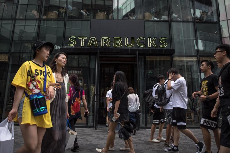 epa06904445 Chinese people walk past a branch of the American coffee chain Starbucks in Beijing, China, 22 July 2018. US President Donald Trump said during the interview with the US network CNBC on 20 July that he was ready to impose tariffs on all 500 billion US dollars of imported goods from China. 'I'm ready to go to 500,' said Trump. The US imported 505 billion US dollars worth of goods from China in 2017, according to media.  EPA/ROMAN PILIPEY