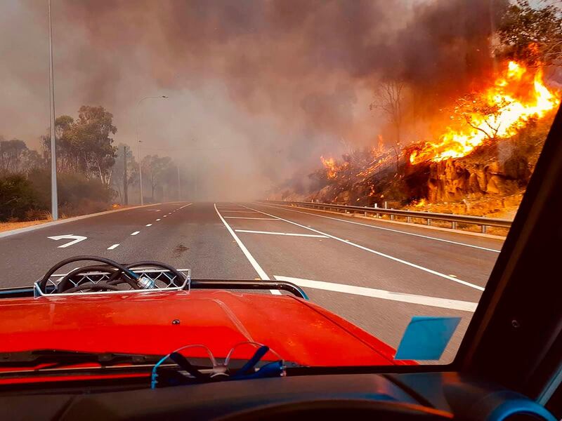 In this photo provided by Department of Fire and Emergency Services, flames approach a road at Wooroloo, near Perth. AP