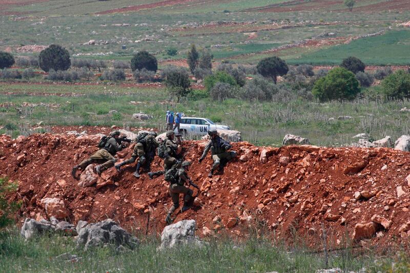 A picture taken on April 18, 2020, in the northern Israeli town of Malkiya, on the border with Lebanon, shows Israeli soldiers monitoring the movement of United Nations Interim Forces in Lebanon (UNIFIL) on the Lebanese side of the border.  / AFP / JALAA MAREY
