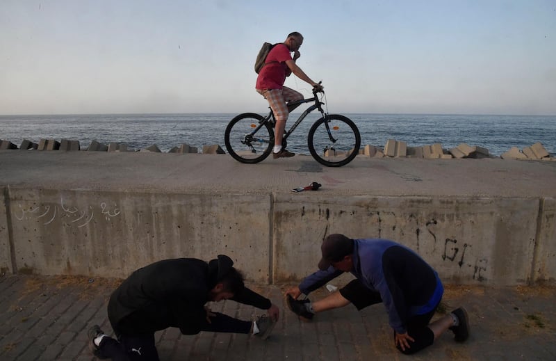 Algerians are pictured at the seafront promenade in the Bab Al Oued district of  Algiers.   AFP
