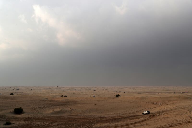 People drive under leaden skies in the Al Qudra desert area of Dubai. Pawan Singh / The National