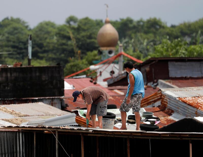Filipino villagers repair a damaged house in flood-hit city Marikina. EPA