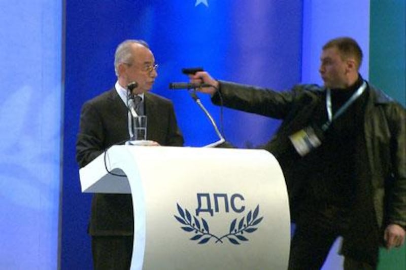 An image from a broadcast by the Bulgarian channel BTV shows a man pointing a gun at Ahmet Dogan, the leader of the MRF party of the Turkish minority in Bulgaria on Saturday. EPA / BTV / HANDOUT
