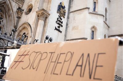A placard left outside the High Court, where the ruling on Rwandan deportation flights took place. AP