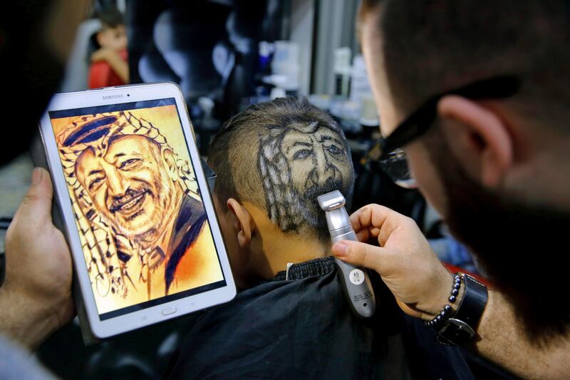 
                  In this Friday, July 14, 2017 photo, Muhannad Khaled Omar, shaves an image of the late Palestinian leader Yasser Arafat on the back of a customer's head at his barber shop in Burj al-Barajneh, southern Beirut, Lebanon. In a city full of hair stylists, Omar stands out. He is a 26 year-old Palestinian-Syrian hair stylist known for shaving celebrity portraits into clients’ hair. (AP Photo/Bilal Hussein)
               