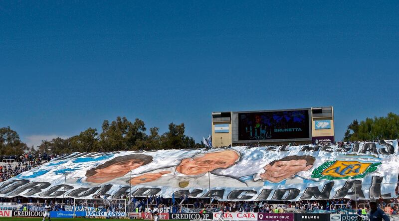 Fans of Gimnasia hold giant banner reading "National proud" depicting Diego Maradona, Pope Francis and Argentine football star Lionel Messi. AFP