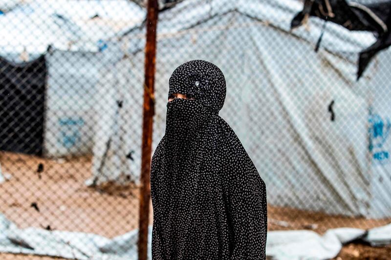 TOPSHOT - A veiled woman looks on during the release of persons suspected of being related to Islamic State (IS) group fighters from the Kurdish-run al-Hol camp in Hasakeh governorate in northeastern Syria, on January 19, 2021.  / AFP / Delil SOULEIMAN
