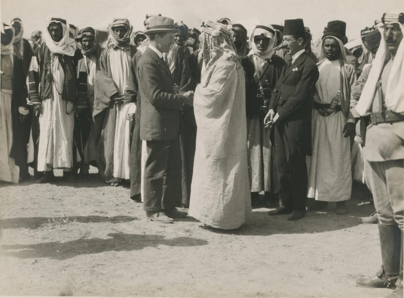T. E. Lawrence, shaking hands with Amir Abdullah, with other men gathered around behind them. Meetings of British, Arab, and Bedouin officials in Amman, Jordan, April. Courtesy Library of Congress, Prints & Photographs Division