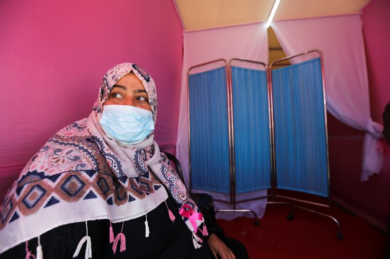 A woman waits to be examined inside the lorry, which is decorated in pink.