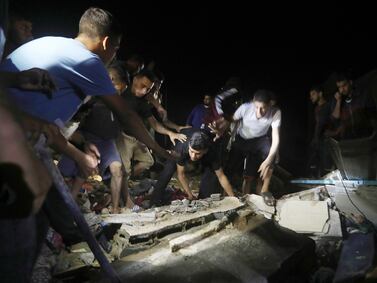Palestinians search for survivors after an Israeli airstrike on a residential building of the Karaja family in Nusseirat refugee camp, central Gaza Strip, early Tuesday, May 14, 2024. (AP Photo/Ismael Abu Dayyah)