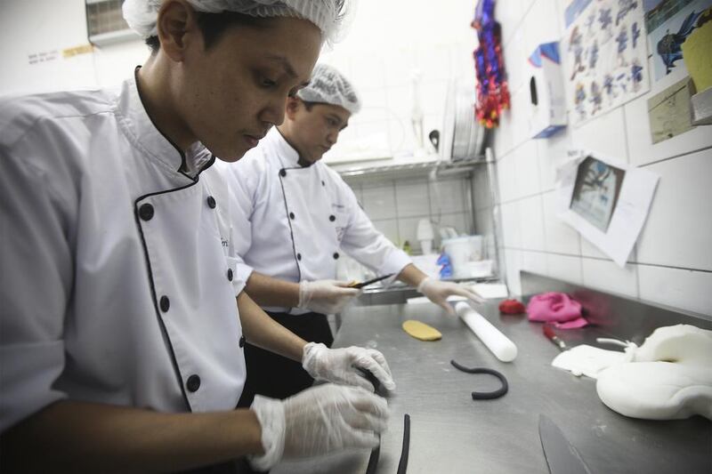Miss J Cafe was established in 1997 and has built a reputation for making unique cakes. Located in Khalidya, it is a popular destination for UAE citizens in particular. Seen here are Paul Salas, left, and Romeo Aragon putting the final touches on a cake in the shape of a doctor’s smock. Lee Hoagland / The National 