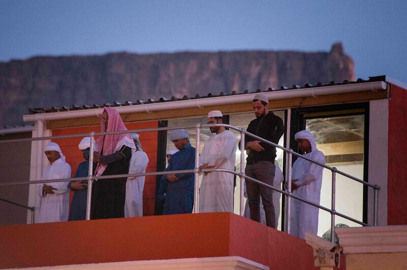 Members of a Muslim family perform the evening prayer after the evening fast-breaking meal, Iftar, during the Muslim fasting month of Ramadan, on a balcony in Bo-Kaap, Cape Town, South Africa. AFP