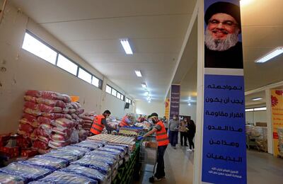 A picture taken during a guided tour organised by the Lebanese Shiite movement Hezbollah shows volunteers sorting food aid that will be distributed to improvised people during the COVID-19 coronavirus pandemic, at a centre in Beirut's southern suburbs on March 31, 2020. / AFP / -
