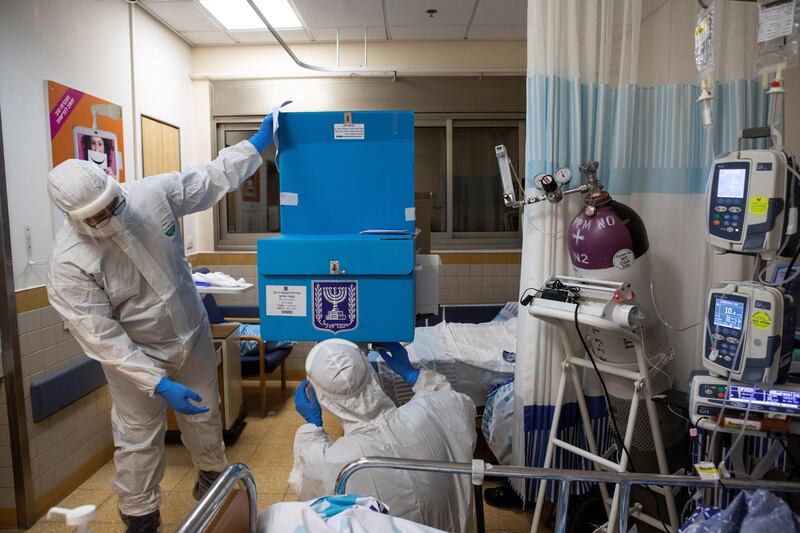 Hospital employees wearing PPE, adjust a mobile voting booth and box inside in a ward for the treatment of the coronavirus disease. Reuters