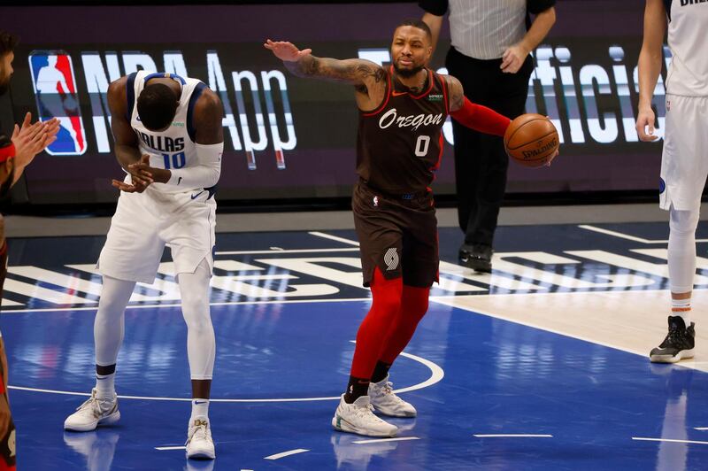 Portland Trail Blazers guard Damian Lillard (0) reacts to a call of a jump ball as Dallas Mavericks forward Dorian Finney-Smith (10) celebrates during the first half of an NBA basketball game in Dallas, Sunday, Feb. 14, 2021. (AP Photo/Michael Ainsworth)