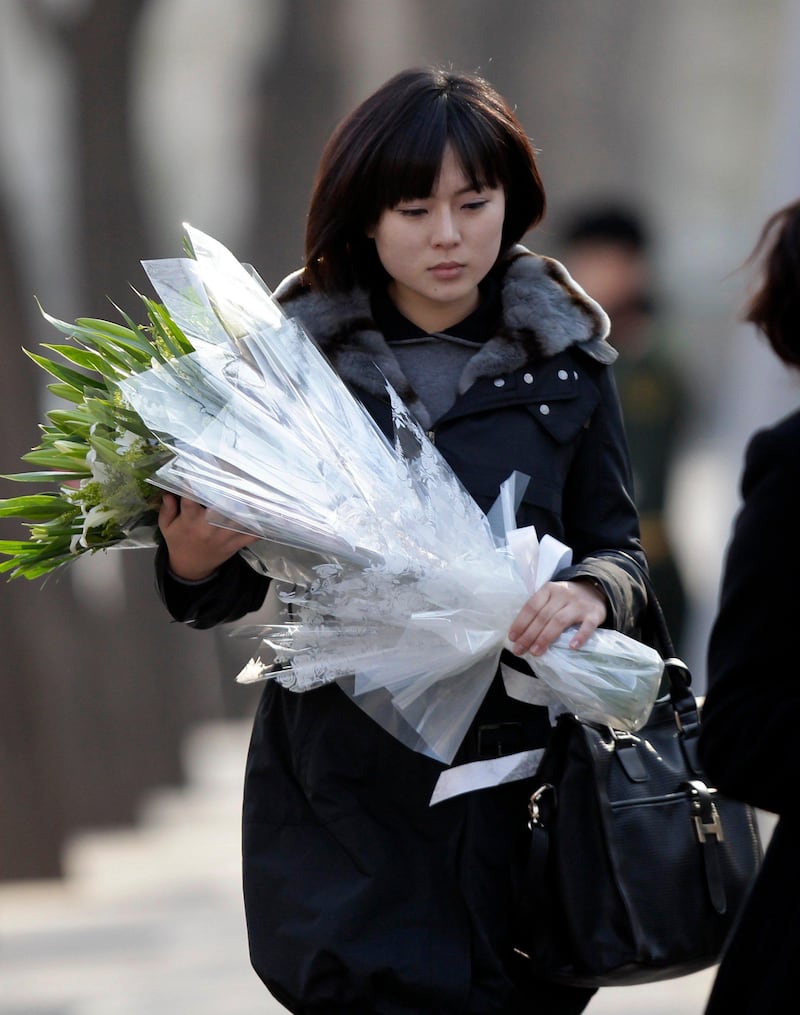 A North Korean woman holding flowers arrives at the North Korea embassy to mourn the death of North Korean leader Kim Jong-il in Beijing December 19, 2011. North Korean leader Kim Jong-il died on Saturday, state television reported on Monday. Kim died on a train trip on Saturday, state television reported on Monday, sparking immediate concern over who is in control of the reclusive state and its nuclear programme. REUTERS/Jason Lee (CHINA - Tags: POLITICS OBITUARY) *** Local Caption ***  PEK309_KOREA-NORTH-_1219_11.JPG
