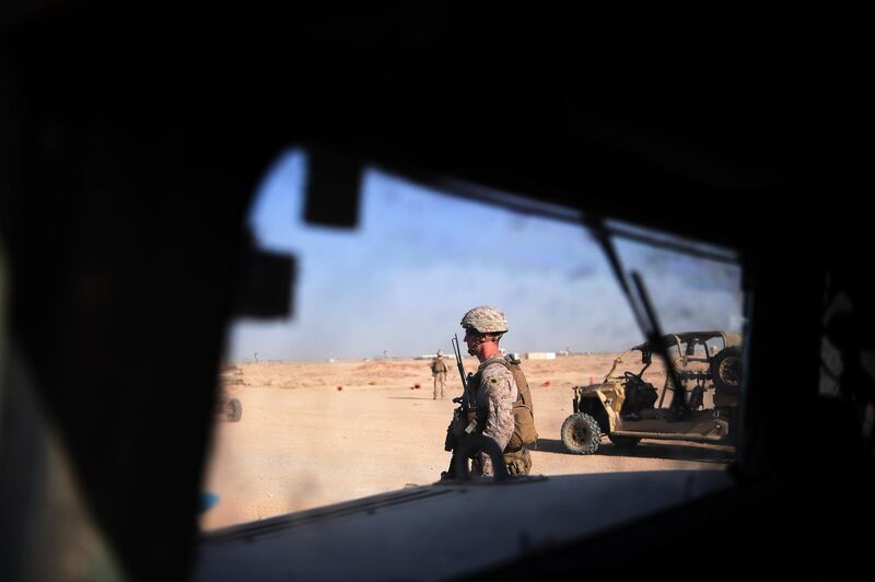 (FILES) In this file photo taken on August 27, 2017 US Marines keep watch as unseen Afghan National Army soldiers participate in an IED (improvised explosive device) training exercise at the Shorab Military Camp in Lashkar Gah in the Afghan province of Helmand. - The Trump administration is getting ready to pull back thousands of troops from Afghanistan as part of a peace deal with the Taliban to begin negotiating directly with the Afghan government. (Photo by WAKIL KOHSAR / AFP)