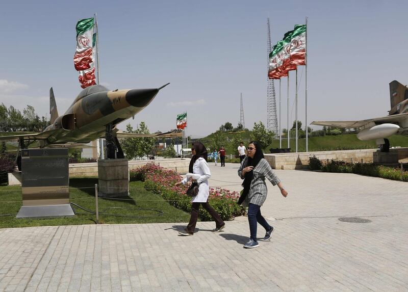 Iranians walk by a fighter jet at the Holy Defence Museum in the capital Tehran on July 17, 2018. The museum displays items from the 1980-88 Iran-Iraq war which was the longest conventional war of 20th century and was officially started on September 22, 1980, when Iraqi armed forces invaded western Iran and ended on August 20, 1988, when the Islamic republic accepted the United Nation's ceasefire resolution 598. / AFP / ATTA KENARE
