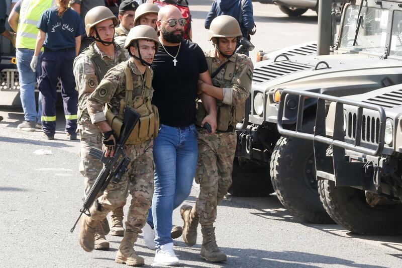 Lebanese army soldiers escort a demonstrator during their attempt to open a blocked road in Zouk Mosbeh, Lebanon November 5, 2019. REUTERS/Mohamed Azakir