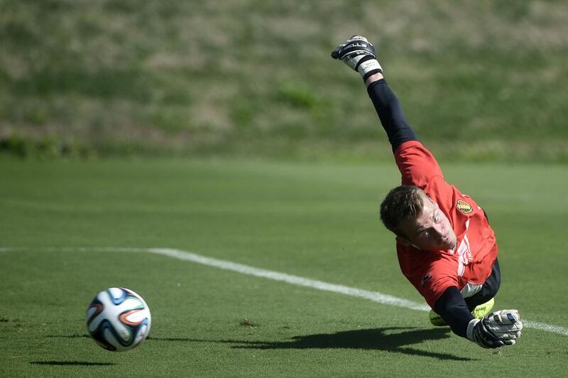 Belgium’s goalkeeper Simon Mignolet dives for a ball as he takes part in a training session in Mogi das Cruzes on June 27, 2014. Martin Bureau / AFP 