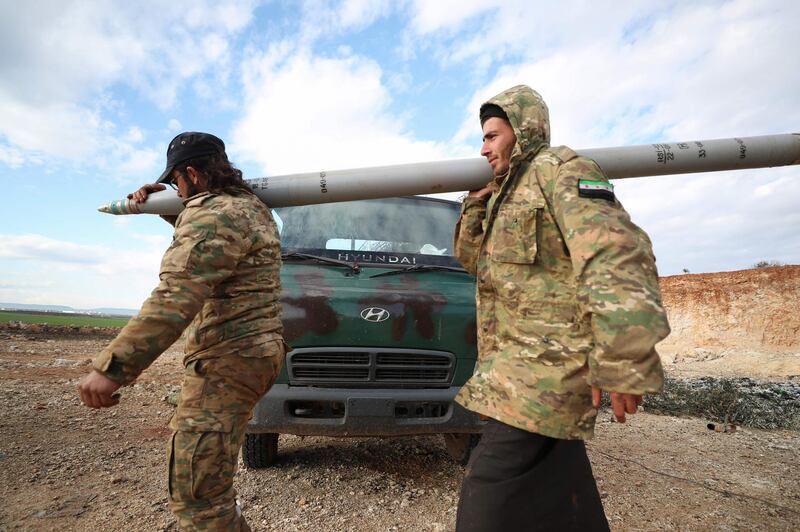 Syrian rebel fighters carry a Grad rocket in northwestern Syria.  AFP