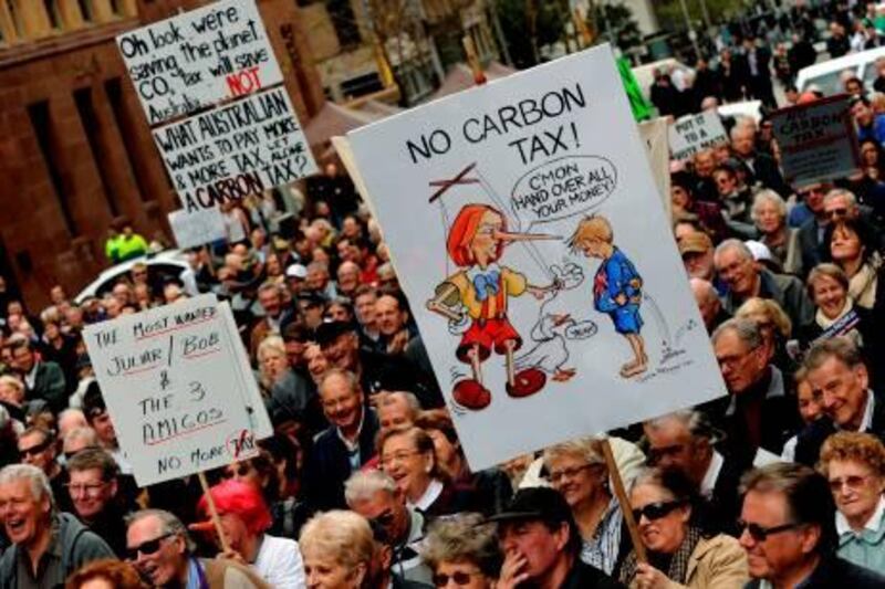 In a picture taken on July 1, 2011 a protester holds a placard during a rally in Sydney against Australian Prime Minister Julia Gillard's planned carbon tax. Australia on July 10, 2011 announced plans to tax carbon pollution at Aus$23 (US$24.74) per tonne to help battle climate change, as it moves towards creating the biggest emissions trading scheme in the region.  AFP PHOTO / Greg WOOD

 *** Local Caption ***  391094-01-08.jpg