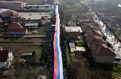 Protesters carry a giant Serbian flag during a barricade protest in Kosovo. AP 