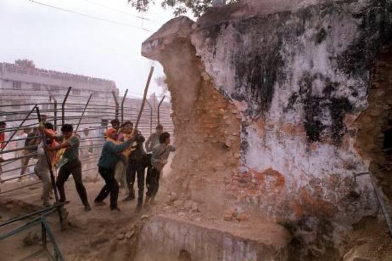 (FILES) In this December 6, 1992 photograph, Indian Hindu fundamentalists attack the wall of the 16th century Babri Masjid Mosque with iron rods at a disputed holy site in the city of Ayodhya. An Indian court ruled September 30, 2010 that a disputed holy site in Ayodhya with a history of triggering Hindu-Muslim clashes should be divided -- a judgement seem as favouring the Hindu litigants. In 1992, the demolition of the 16th-century Babri Mosque in Ayodhya by Hindu activists sparked riots that killed more than 2,000 people, mostly Muslims, and propelled India's Hindu nationalists into the political mainstream. AFP PHOTO/DOUGLAS E CURRAN/FILES
 *** Local Caption ***  303098-01-08.jpg