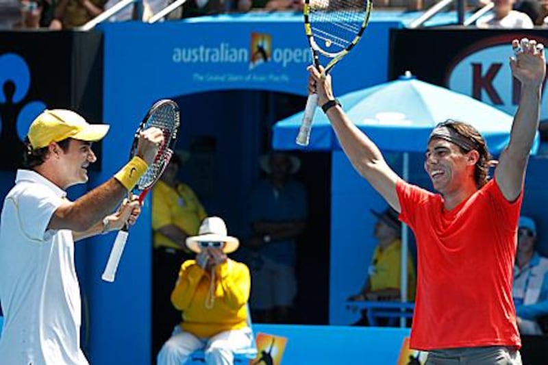 Roger Federer, left, and Rafael Nadal celebrate a point during a charity tennis event in Melbourne yesterday. The event is being held to raise money for the flood disaster that has caused 26 deaths in Australia.