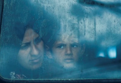 Displaced Palestinians in Gaza look out from a bus window. One-quarter of the population is one step away from famine, the UN said. Reuters