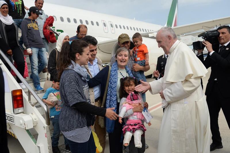 Pope Francis welcomes Syrian refugees to Italy after landing at Ciampino airport in Rome following a visit to the Moria refugee camp on the Greek island of Lesbos on April 16, 2016. Filippo Monteforte/AFP Photo 

