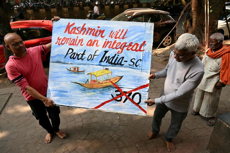 An art school teacher in Mumbai on Monday with a painting depicting the Supreme Court's verdict on Article 370. AFP