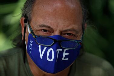 A poll worker waits for voters to arrive at a polling station in the Miami Beach Botanical Garden. AP
